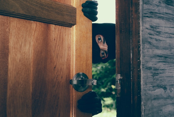 Hombre intruso abriendo la puerta de una vivienda